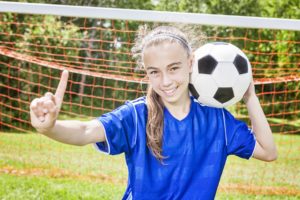 A young soccer player smiling and wearing braces