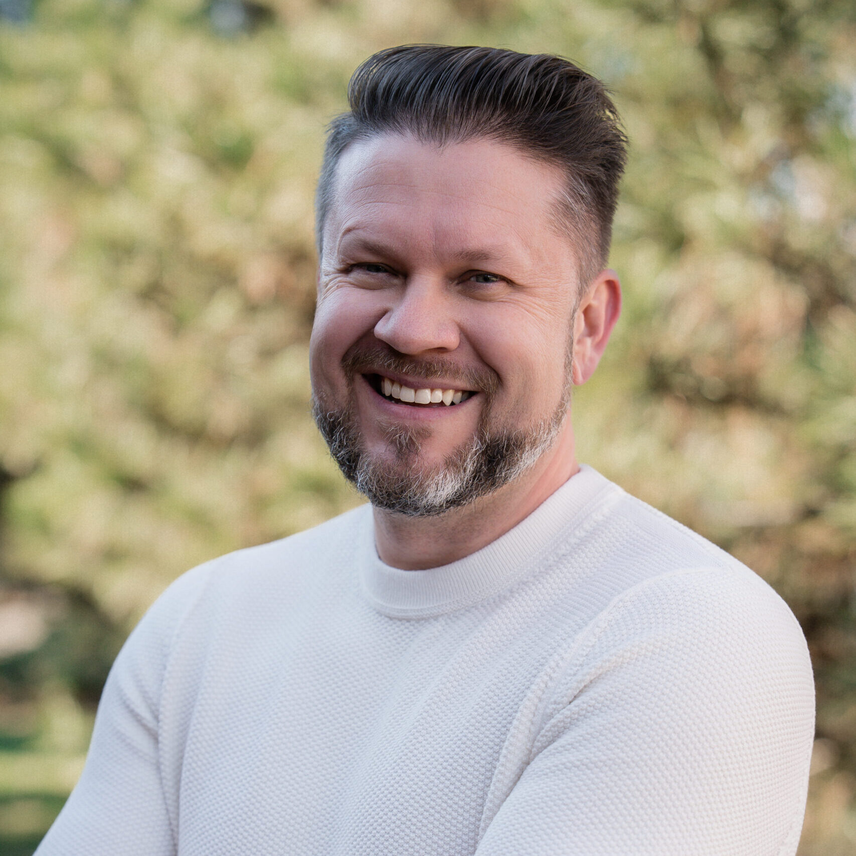 Dr. Ken Dillehay smiling in a white sweater, representing Dillehay Orthodontics, a Wichita orthodontist offering braces and Invisalign for families in Wichita and Derby.