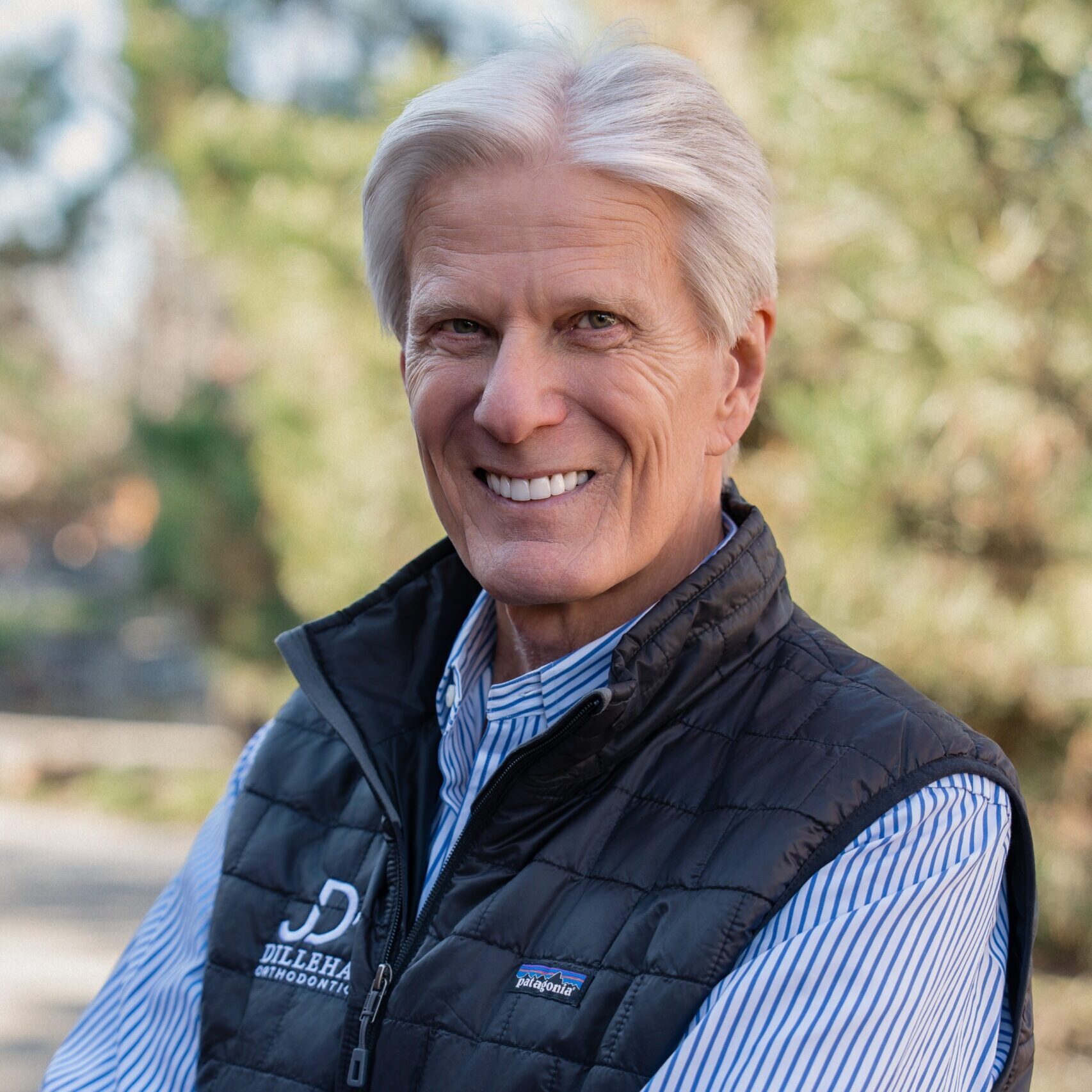 Dr. Ken Dillehay, board-certified orthodontist at Dillehay Orthodontics, smiling in a black vest, promoting orthodontic care in Wichita and Derby, specializing in braces and Invisalign.